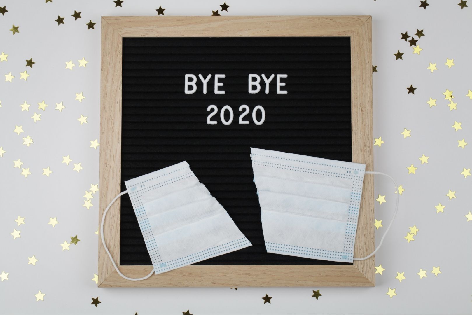 board that says bye bye 2020 with a ripped facemask