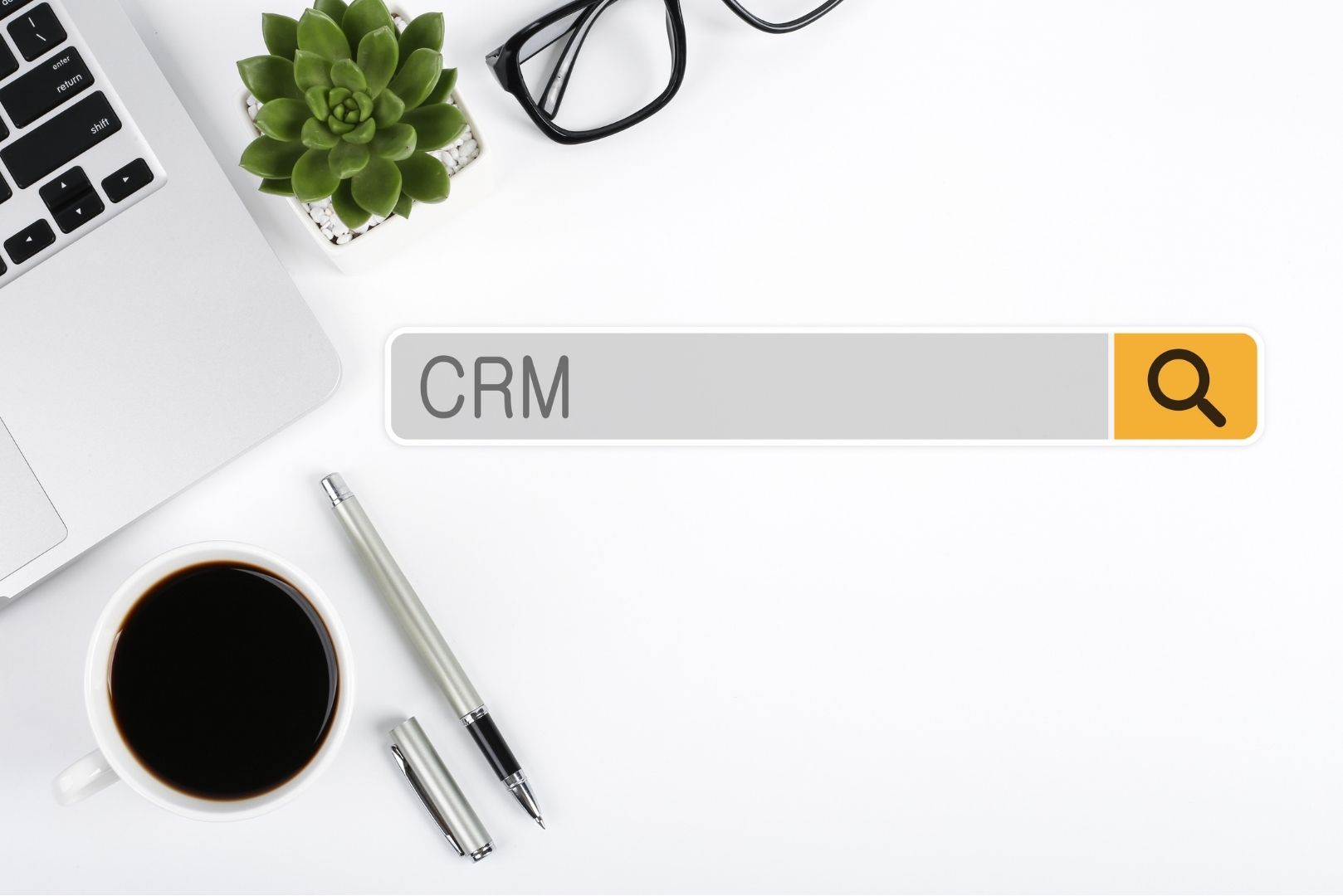 an office desk with coffee and pen doing a "CRM" search