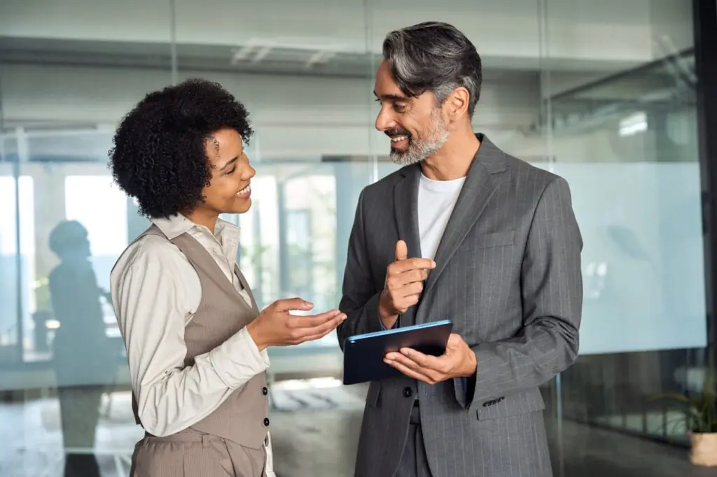 Two investment professionals discussing a SatuitCRM vs Junxure comparison in the office