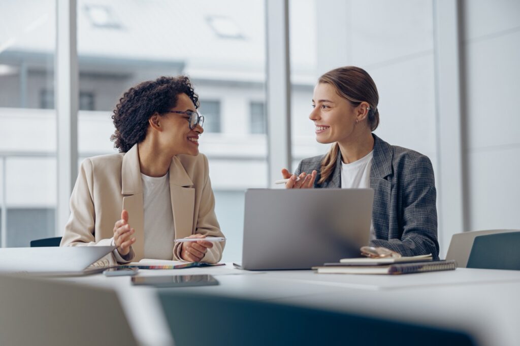 Two investment professionals discussing a SatuitCRM vs Maximizer comparison at a laptop