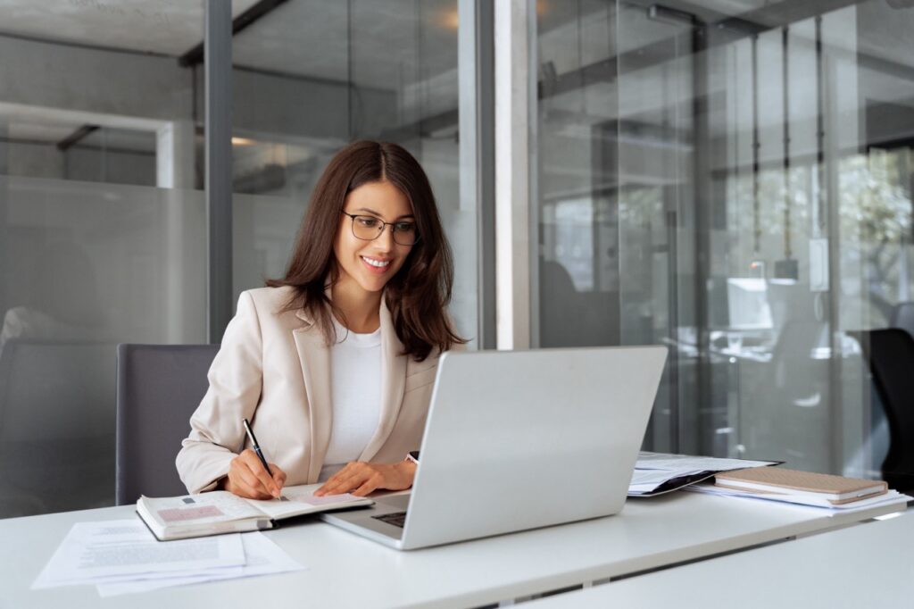 Emerging fund manager taking notes at a laptop while deciding when to implement a CRM
