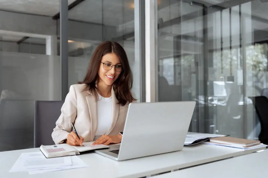Emerging fund manager taking notes at a laptop while deciding when to implement a CRM