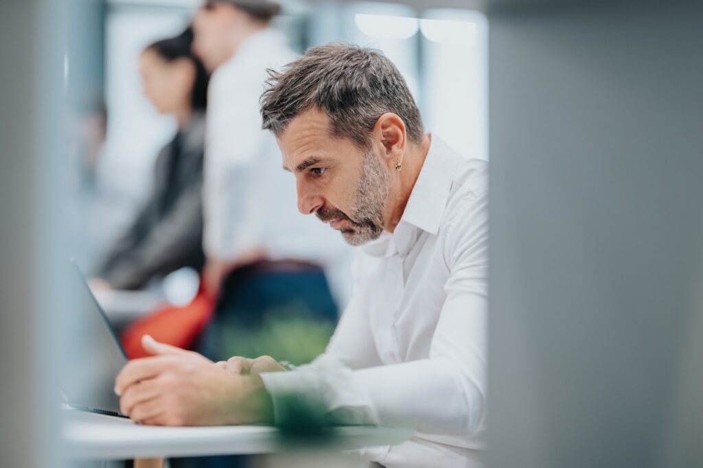 Fund manager reviewing a SatuitCRM vs Freshworks CRM comparison on a laptop