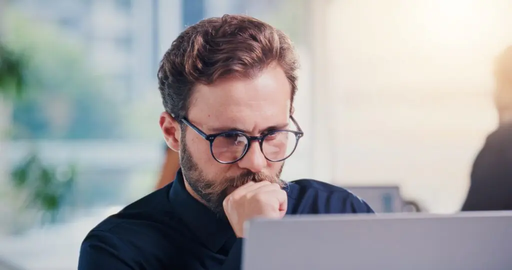 Investment professional reading investor email on a laptop using the SatuitCRM Outlook add-in